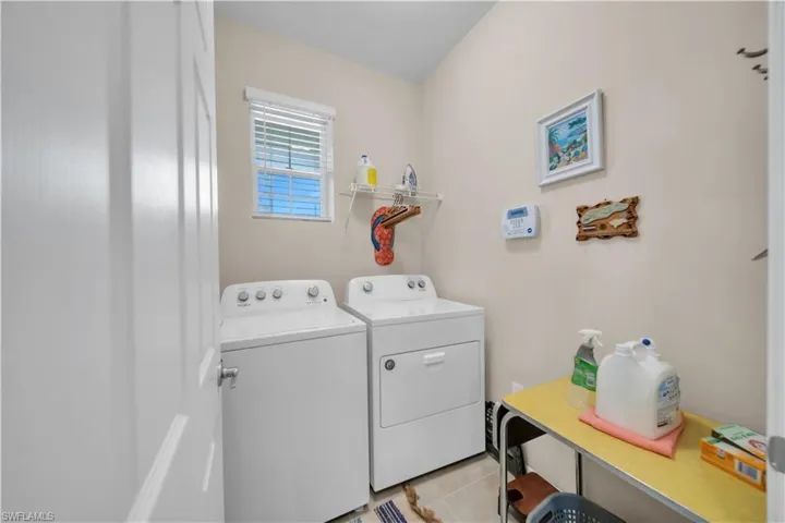 Laundry room featuring light tile patterned flooring and washing machine and dryer