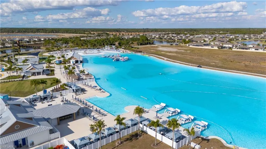 Aerial view of residential area with a nearby body of water and a pool