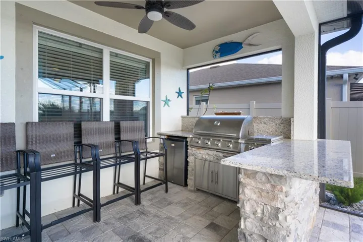 View of patio with an outdoor kitchen and ceiling fan