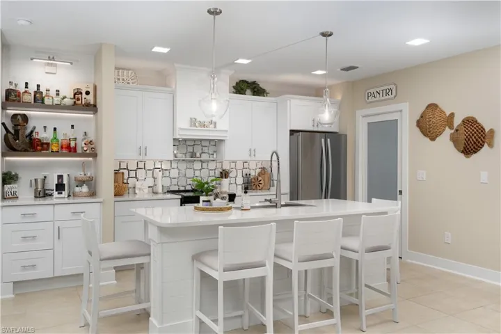 Kitchen with open shelves, a kitchen breakfast bar, white cabinetry, and decorative backsplash