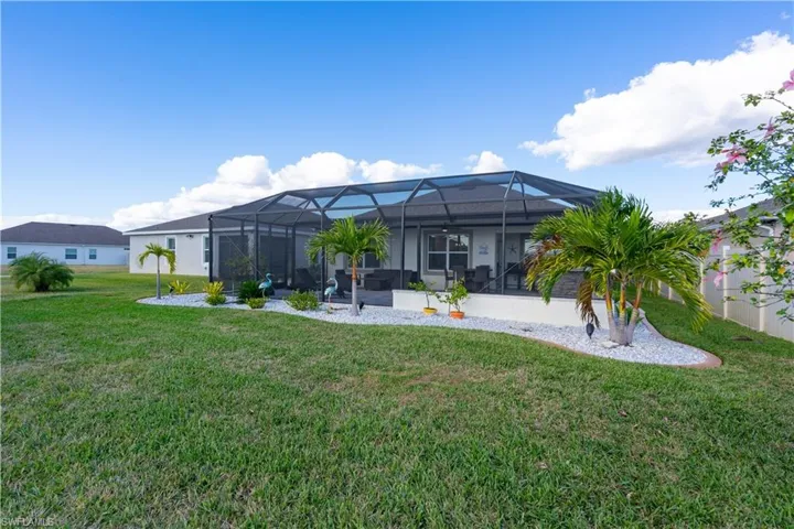 Back of property featuring a lanai, a yard, a sunroom, and a patio