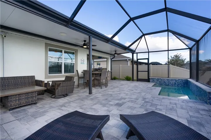 Fenced backyard with glass enclosure, a patio area, an outdoor living space, a sunroom, and a ceiling fan