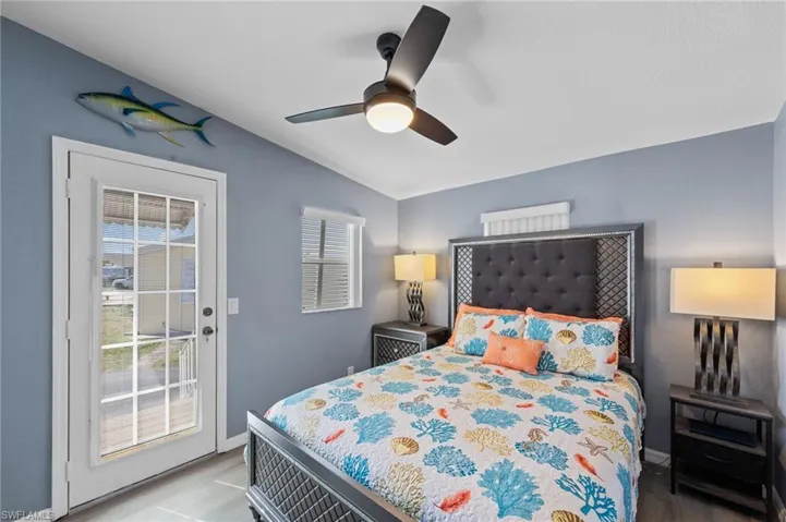 Bedroom featuring access to outside, lofted ceiling, and a ceiling fan