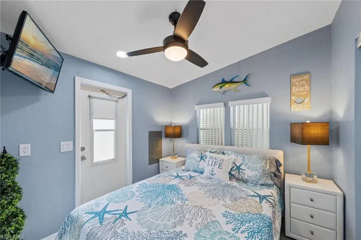 Bedroom featuring a ceiling fan, electric panel, and a textured wall