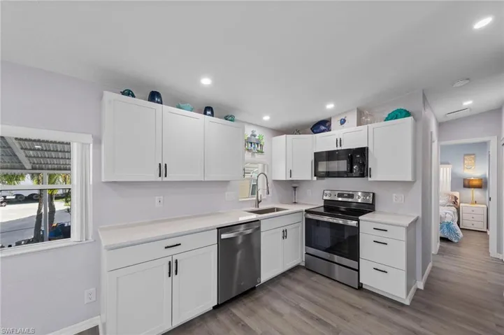 Kitchen featuring stainless steel appliances, white cabinetry, light wood-type flooring, and recessed lighting