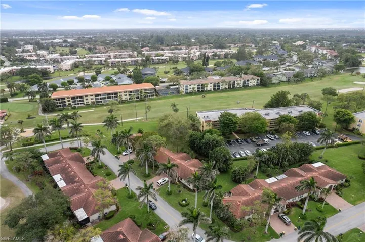 Aerial overview of property's location with a golf club and apartment complex / building