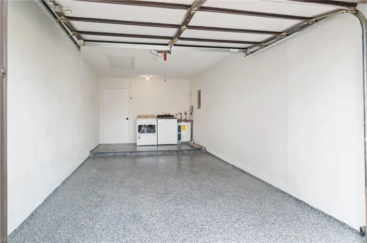 Garage featuring separate washer and dryer and water heater