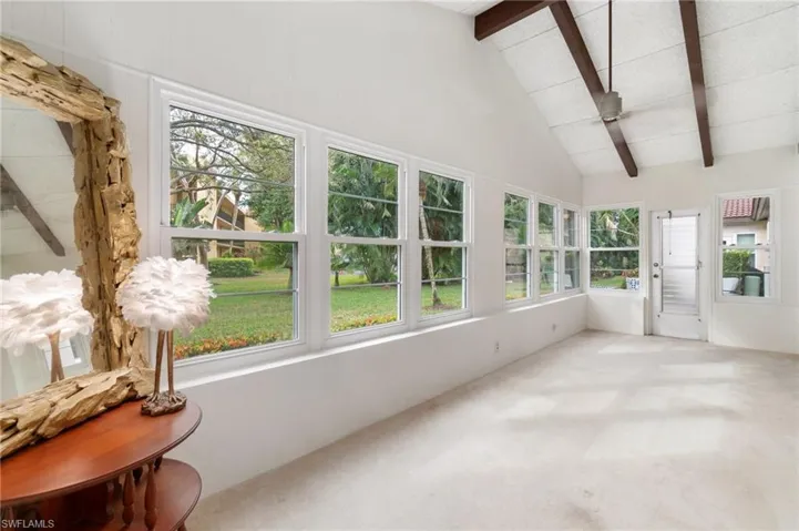 Sunroom featuring plenty of natural light, carpet floors, and vaulted ceiling