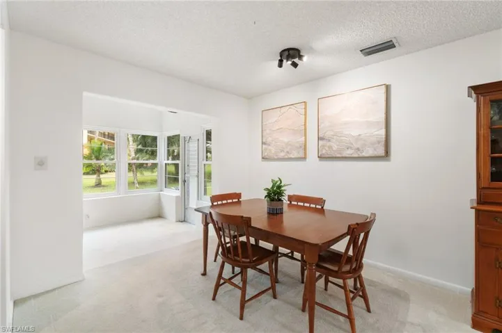 Dining area with light carpet and a textured ceiling
