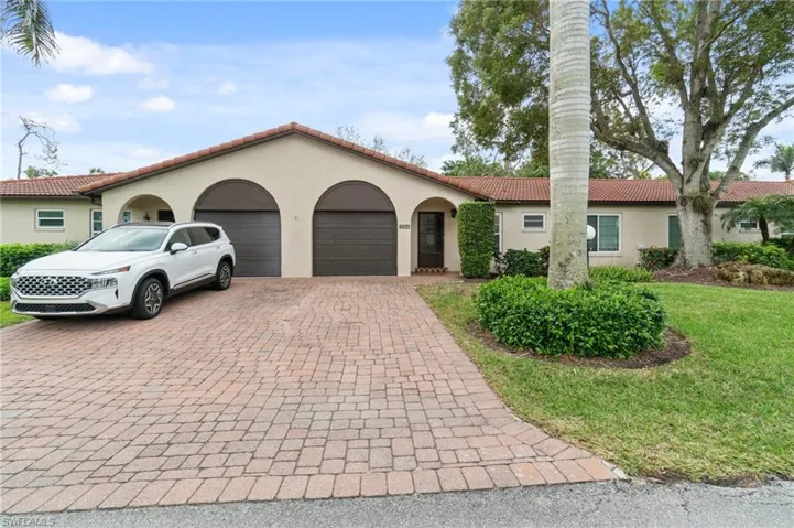 Mediterranean / spanish-style house featuring a tile roof, an attached garage, stucco siding, decorative driveway, and a front lawn