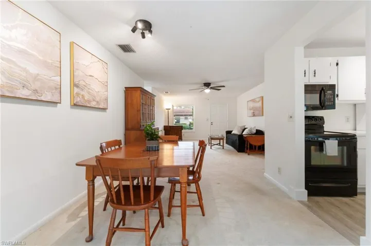 Dining space featuring ceiling fan and light carpet