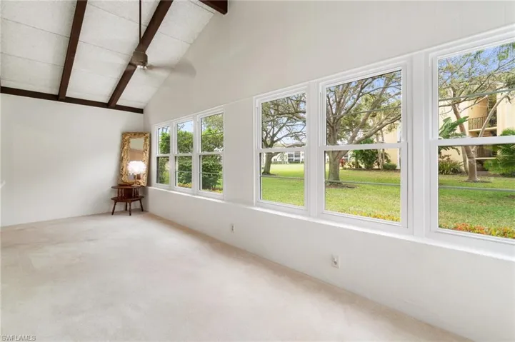Unfurnished sunroom featuring carpet floors and vaulted ceiling