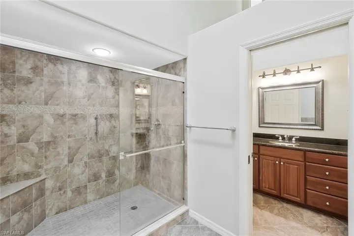 Over Sized Tiled Shower With Glass Doors and Seat