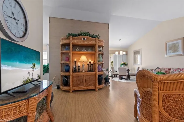 Living room featuring wood finished floors, vaulted ceiling, and hanging lights