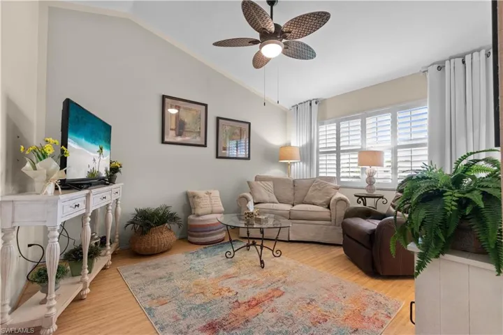 Second living area featuring bamboo floors, plantation shutters, and vaulted ceiling.