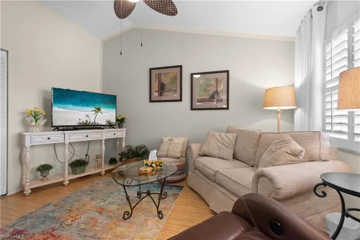 Second living area featuring bamboo floors, plantation shutters, and vaulted ceiling.