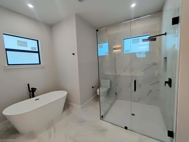Full bath with a marble finish shower, recessed lighting, a soaking tub, and marble finish flooring