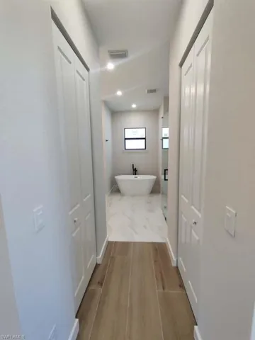 Hall with light wood finished floors and baseboards