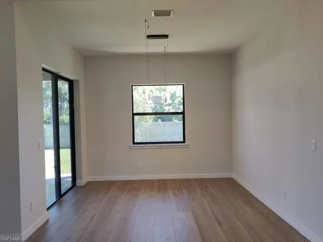 Unfurnished dining area featuring light wood-style flooring and baseboards