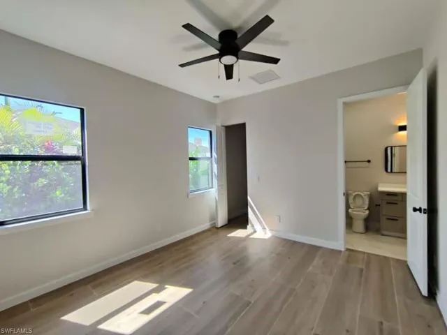 Unfurnished bedroom featuring light wood-type flooring, ceiling fan, and ensuite bathroom
