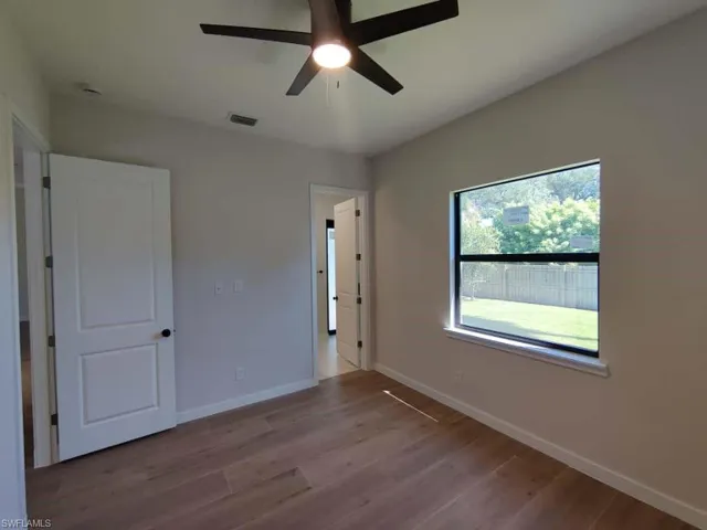 Unfurnished bedroom featuring wood finished floors and ceiling fan