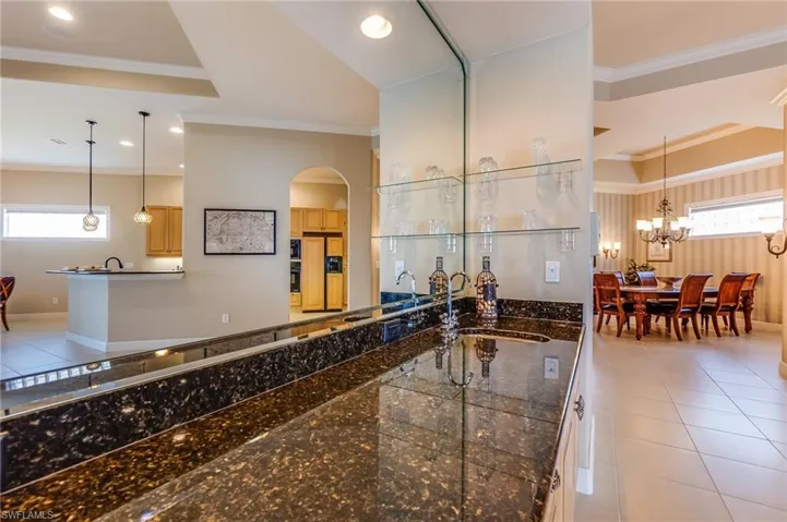 Kitchen featuring sink, crown molding, a notable chandelier, decorative light fixtures, and light tile patterned floors
