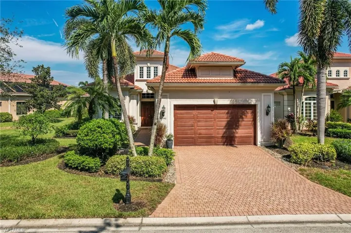 Mediterranean / spanish-style home with a garage and a front lawn