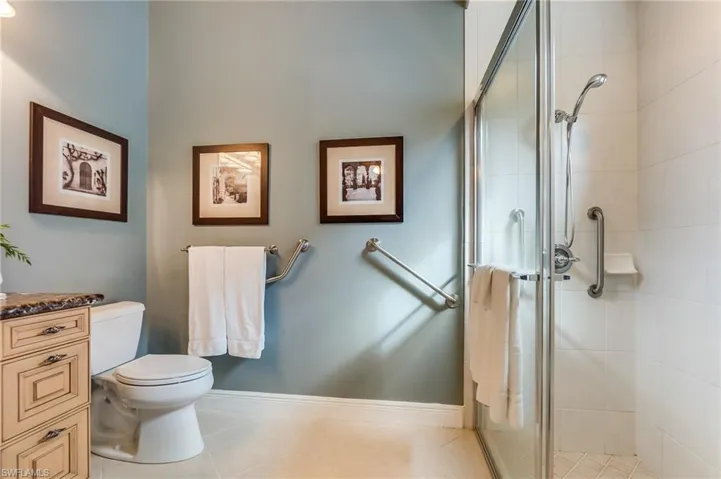 Bathroom featuring vanity, a shower with shower door, toilet, and tile patterned floors