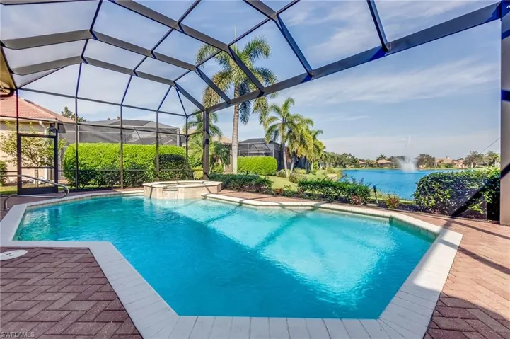 View of swimming pool with a patio, an in ground hot tub, a water view, and a lanai