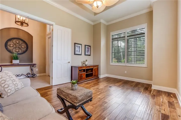 Living room featuring crown molding, hardwood / wood-style flooring, and ceiling fan