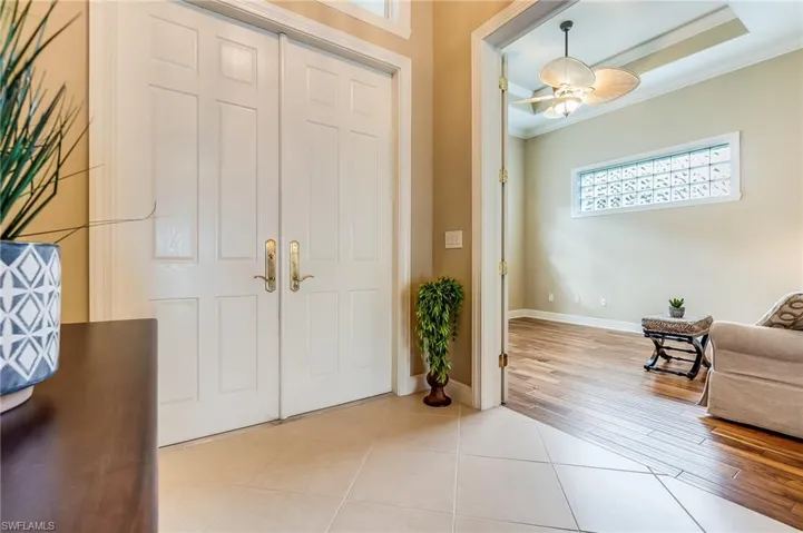Foyer entrance featuring light hardwood / wood-style floors, ornamental molding, and ceiling fan