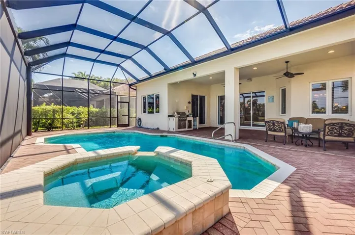 View of swimming pool featuring a grill, an in ground hot tub, a patio area, glass enclosure, and ceiling fan