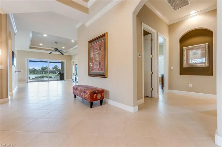 Corridor featuring ornamental molding and light tile patterned flooring