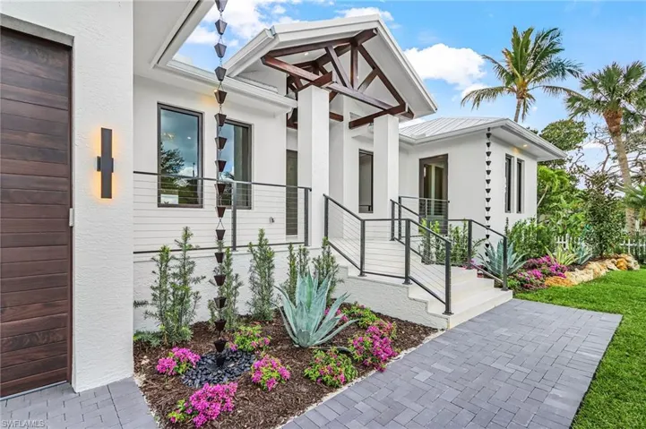 View of exterior entry featuring stucco siding and a metal roof