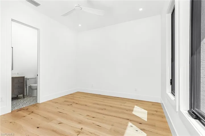 Unfurnished bedroom with wood finished floors, connected bathroom, ceiling fan, and recessed lighting