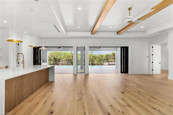 Unfurnished living room featuring beamed ceiling, recessed lighting, light wood-type flooring, plenty of natural light, and ceiling fan