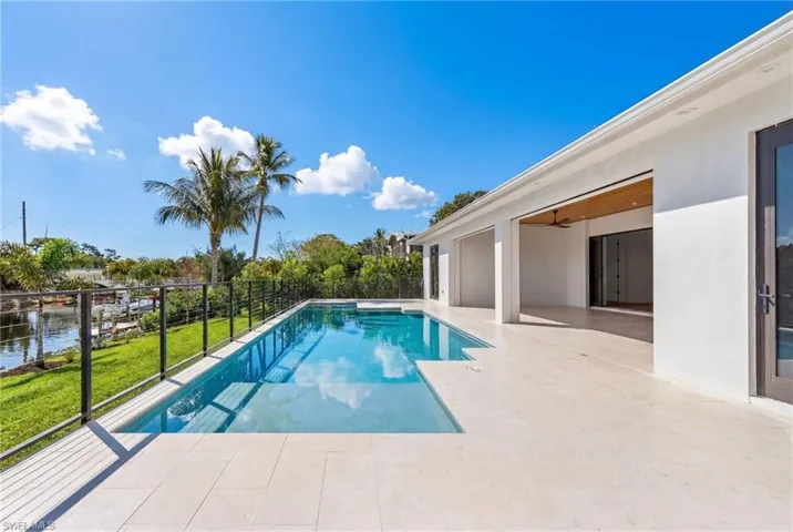 View of pool with patio surround and a water view