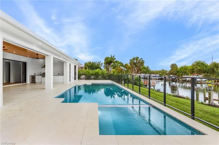 Combined pool / hot tub featuring a patio area, area for grilling, and a water view
