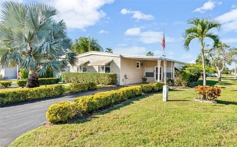 View of front of house featuring a front lawn, a carport, and covered porch