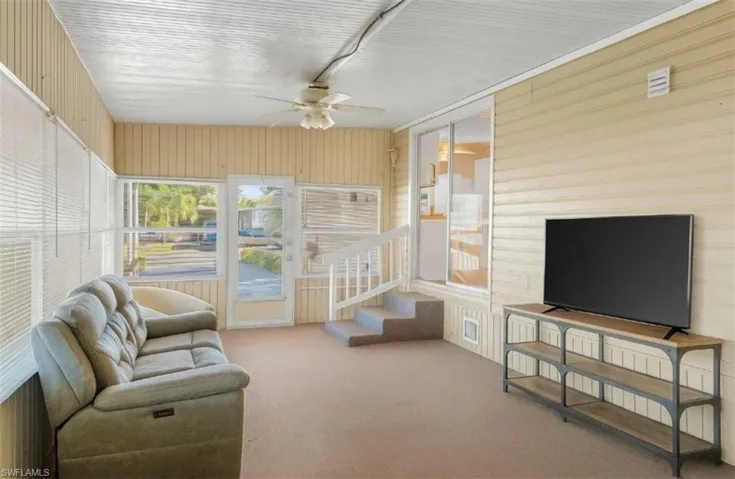 Sunroom with ceiling fan and carpet flooring