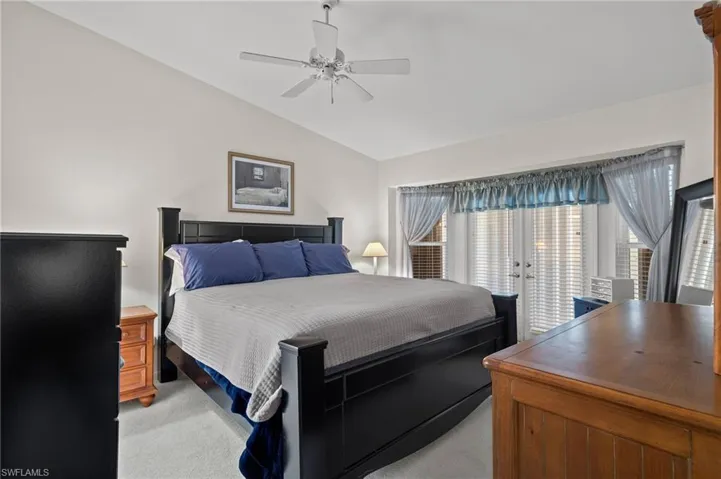 Bedroom with lofted ceiling, access to outside, light carpet, ceiling fan, and french doors