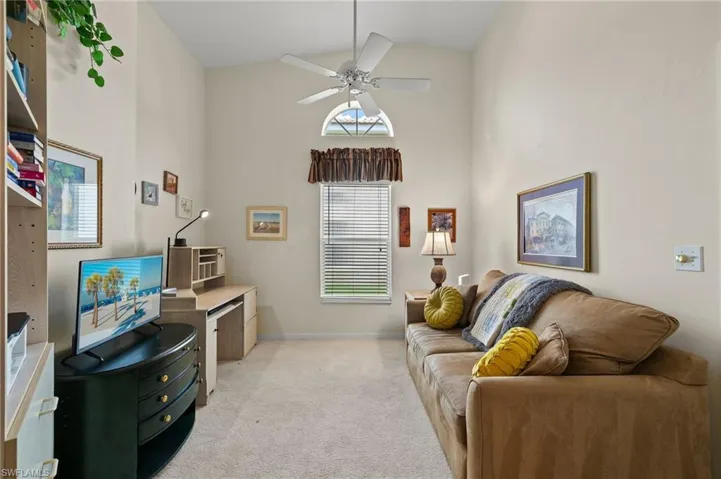 Den featuring high vaulted ceiling, ceiling fan, and light colored carpet