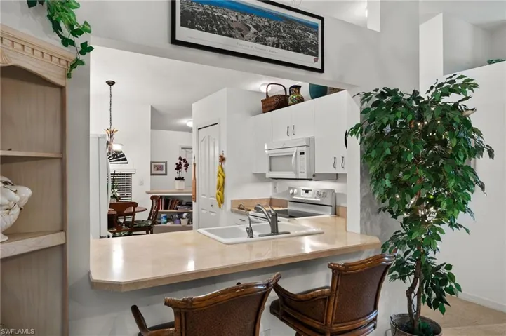 Kitchen with white cabinets, a kitchen bar, and kitchen peninsula