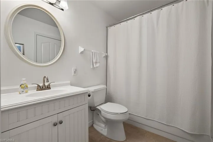 Full bathroom featuring shower / tub combo, vanity, toilet, and tile patterned floors