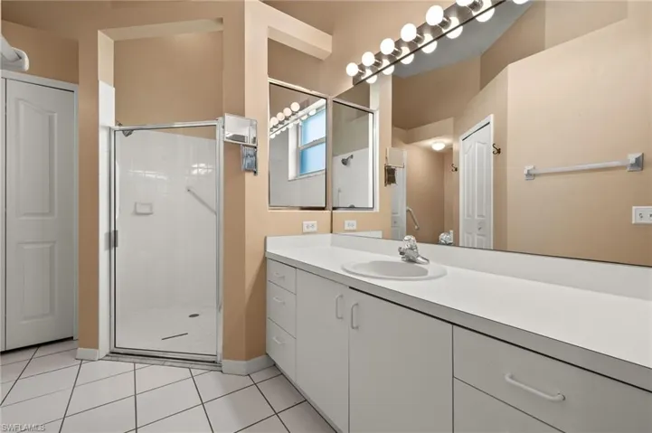 Bathroom with vanity, tile patterned flooring, and an enclosed shower