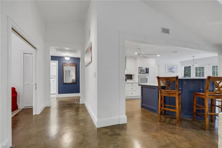 Hallway featuring concrete floors and vaulted ceiling