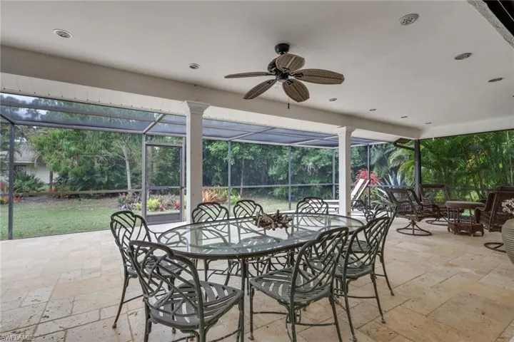 View of patio enclosure, outdoor dining area, a ceiling fan, recessed lighting, travertine tiled flooring