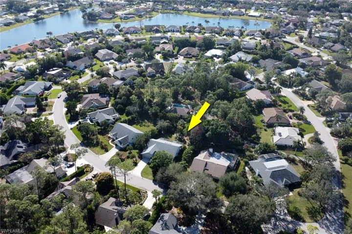 Woodland's arrow is pointing to 2293 Royal Lane with the Woodlands Pool in the background surround by lush tropical folige of presver area