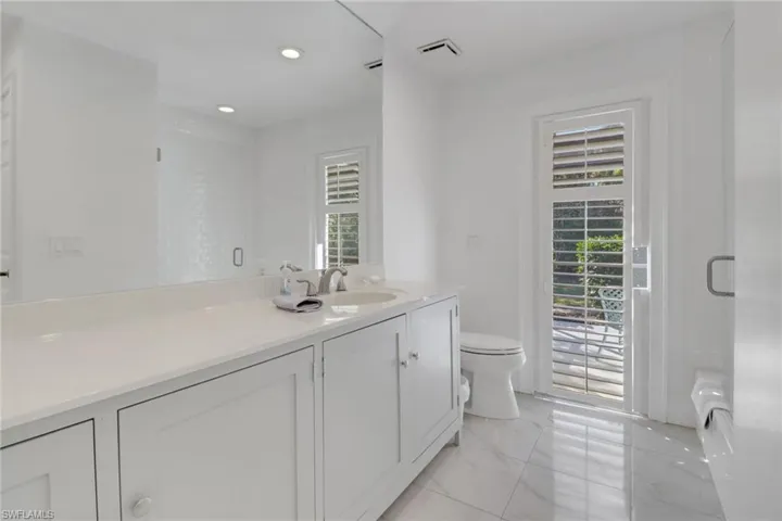 Guest Bathroom features a newer tub and shower combo with subway tile seamless glass shower door, newer solid wood cabinets, water closet