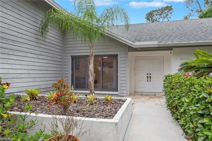 Property entrance featuring roof with shingles